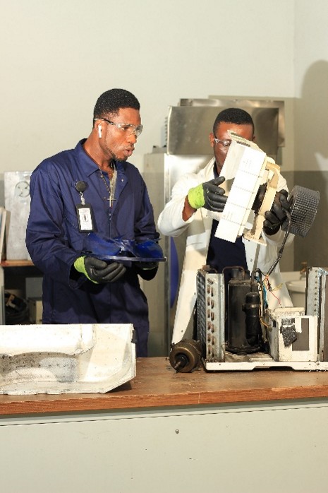 Instructor and trainee inspecting air-conditioning components