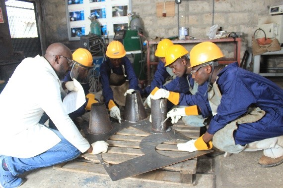 Trainees assembling fabricated cones on the workshop floor