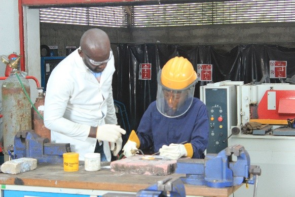 Trainee finishing a workpiece under instructor supervision