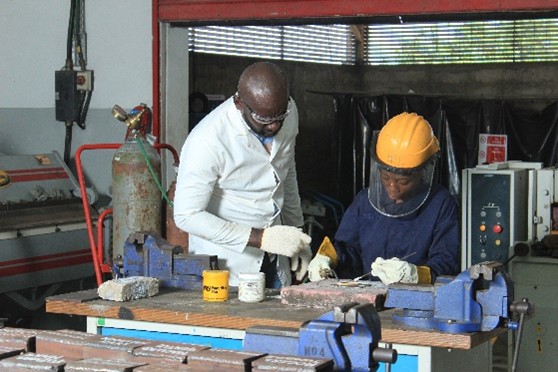 Instructor and trainee working at the bench vice
